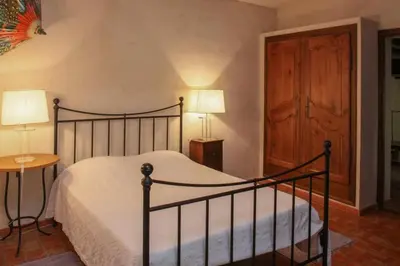 a bedroom with a bed and a table and two lamps at Villa La Familliale, piscine avec vue imprenable sur Gordes in Gordes
