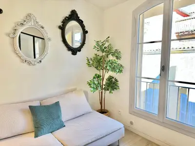 a living room with a couch and a mirror at Appartement chic, hyper centre in Aix-en-Provence