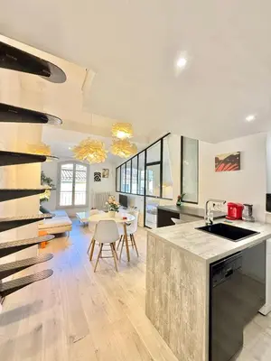 a kitchen with a counter and a dining room at Appartement chic, hyper centre in Aix-en-Provence