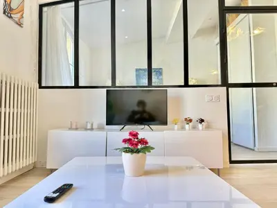 a living room with a table and a tv at Appartement chic, hyper centre in Aix-en-Provence