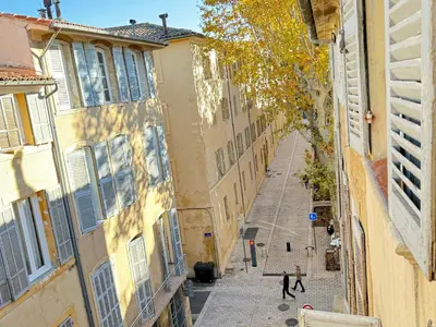 an alley with two people walking down a street at Appartement chic, hyper centre in Aix-en-Provence