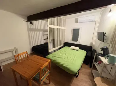 a small bedroom with a green bed and a table at Studio Cosy hyper centre Aix in Aix-en-Provence