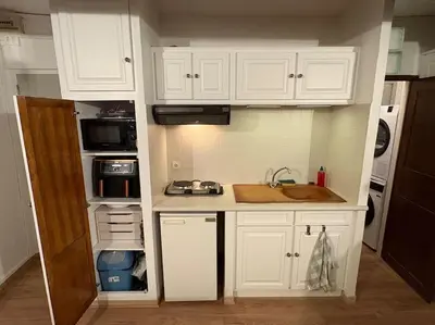 a kitchen with white cabinets and a sink at Studio Cosy hyper centre Aix in Aix-en-Provence