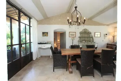 a dining room with a wooden table and chairs at Villa La Raffinée, au coeur des garrigues du Luberon in Gordes