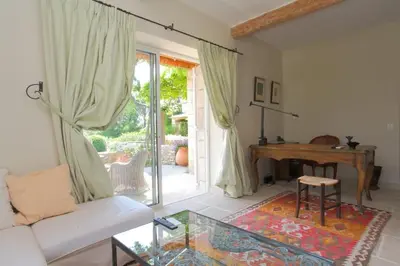 a living room with a table and a piano at Villa l'Écrin, piscine et 3 terrasses in Gordes