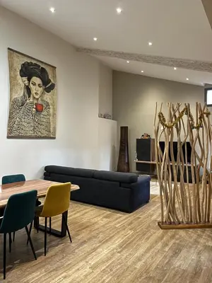 a living room with a couch and a table at Appartement 100 m2 au cœur de l'Isle sur la Sorgue in LʼIsle-sur-la-Sorgue