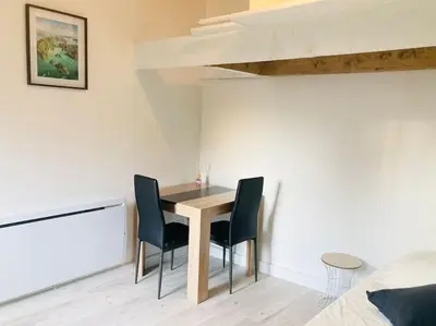 a dining room with a table and two chairs at Maisonnette T1 au calme à 1min à pied de la gare SNCF in Miramas