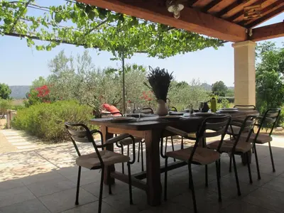a wooden table and chairs on a patio at Villa avec piscine Saint Remy de Provence LS1-196 in Saint-Rémy-de-Provence