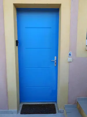 a blue door on the side of a building at Les deux Oliviers in Roussillon