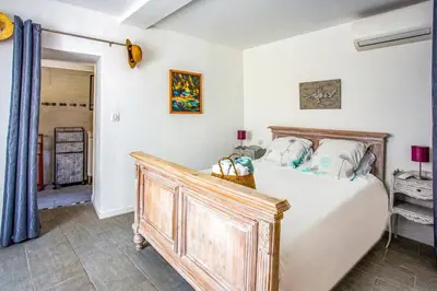 a bedroom with a bed with a wooden headboard at Villa Le Bastidon by Villa Plus in Les Taillades