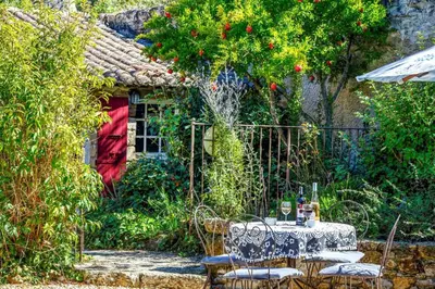 a table and chairs in front of a house at Villa Le Bastidon by Villa Plus in Les Taillades