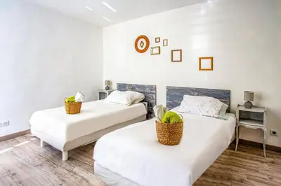 two beds in a room with white walls at Villa Le Bastidon by Villa Plus in Les Taillades