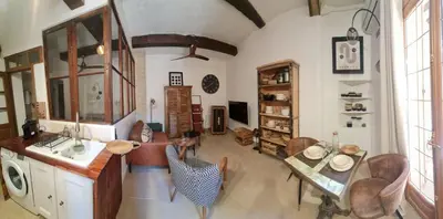 a large living room with a table and chairs at Studio cozy avec terrasse en centre ville in LʼIsle-sur-la-Sorgue