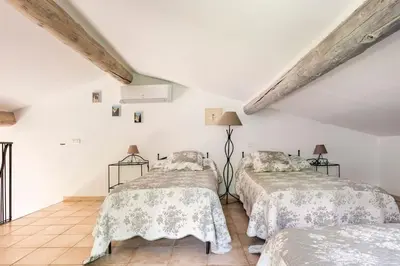 two beds in a room with white walls at Le cabanon, 3 étoiles, sa piscine au pied du Luberon in Saint-Saturnin-les-Apt
