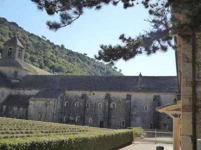 an old stone building with a hill in the background at Le cabanon, 3 étoiles, sa piscine au pied du Luberon in Saint-Saturnin-les-Apt