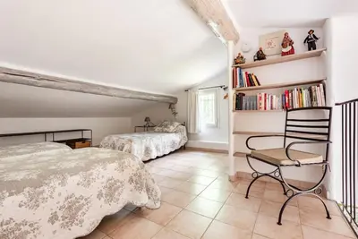 a bedroom with two beds and a book shelf at Le cabanon, 3 étoiles, sa piscine au pied du Luberon in Saint-Saturnin-les-Apt