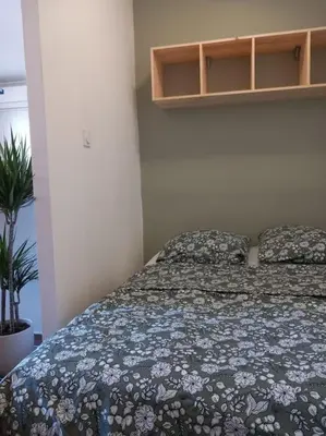 a bedroom with a bed with a floral bedspread at Studio entièrement rénové in Cavaillon