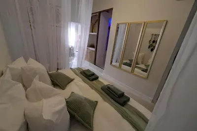 a bedroom with a bed with pillows and a mirror at La Galatée, Balnéo et Sauna privatifs in Saint-Saturnin-lès-Avignon