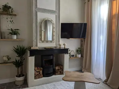 a living room with a fireplace and a mirror at La Galatée, Balnéo et Sauna privatifs in Saint-Saturnin-lès-Avignon