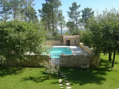 a swimming pool in a yard with a stone wall at Location avec piscine Roussillon LS2-91 in Roussillon