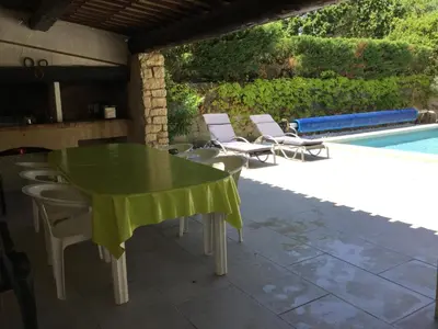 a green table and chairs next to a swimming pool at Maison avec piscine privative Taillades Luberon LS2-281 in Les Taillades