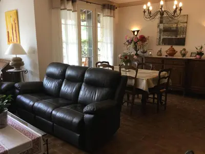 a living room with a black leather couch and a table at Maison avec piscine privative Taillades Luberon LS2-281 in Les Taillades