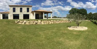 a house with a stone wall and a tree in the yard at Villa avec piscine privative Saint Remy de Provence LS1-340 in Saint-Rémy-de-Provence