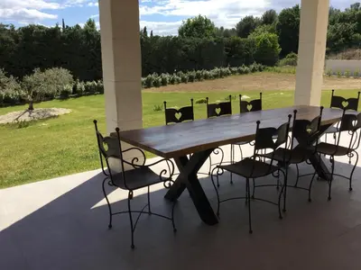a wooden table and chairs sitting on a patio at Villa avec piscine privative Saint Remy de Provence LS1-340 in Saint-Rémy-de-Provence