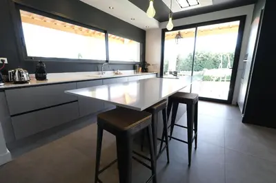 a kitchen with a large white counter and stools at Villa avec piscine privative Saint Remy de Provence LS1-340 in Saint-Rémy-de-Provence