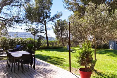 a patio with a table and chairs in a yard at The Maisonnette in the pines in Ventabren