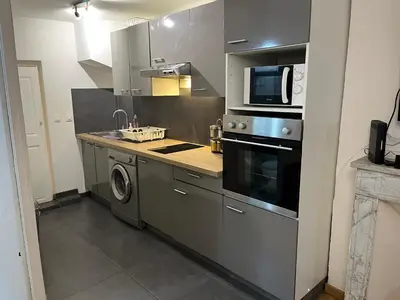 a kitchen with a microwave and a washer and dryer at T2 lumineux hyper centre Aix en Provence à quelques metres du Cours Mirabeau pour 1 à 5 personnes in Aix-en-Provence