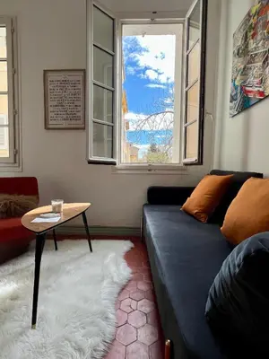 a living room with a blue couch and a table at La Suite Mazarin in Aix-en-Provence