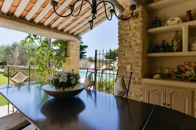 a dining room with a table with a vase on it at Chambre d'hôtes le Jardinage in Cabrières-dʼAvignon