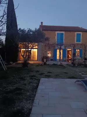 a house with the lights on in a yard at Superbe appartement neuf au cœur de la Provence. in Entraigues-sur-la-Sorgue