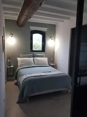 a bedroom with a large bed and a window at Le Cosy Luberon - Viens in Viens