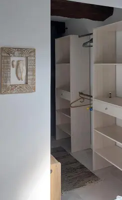 a closet with wooden shelves and a picture on the wall at Le Cosy Luberon - Viens in Viens