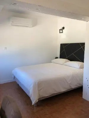 a bedroom with a large white bed in a room at Gite 5 pers en Provence avec grand jardin & piscine partagés - 5 people holiday home with shared swimming pool & garden in Provence in Cornillon-Confoux