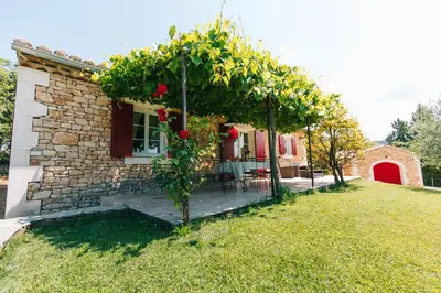 a house with a pergola with roses on it at Location vacances maison piscine LIOUX LS2-92 in Lioux