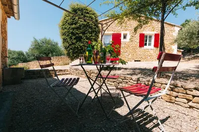 two chairs and a table with bottles on it at Location vacances maison piscine LIOUX LS2-92 in Lioux