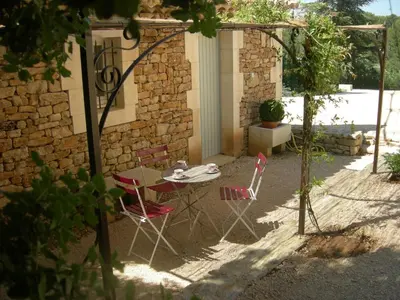 a table and chairs in front of a building at Location vacances maison piscine LIOUX LS2-92 in Lioux