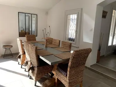 a dining room with a table and wicker chairs at Entre ciel et terre in Le Thor