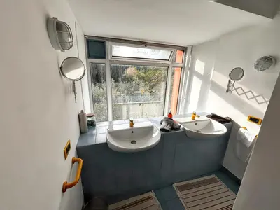 a bathroom with two sinks and a window at Maison spacieuse avec piscine à Aix-en-Provence in Aix-en-Provence