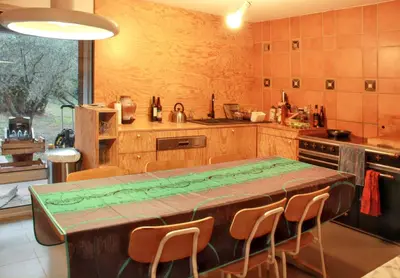 a kitchen with a wooden table and chairs in it at Maison spacieuse avec piscine à Aix-en-Provence in Aix-en-Provence