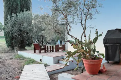 a patio with two chairs and a potted plant at Maison spacieuse avec piscine à Aix-en-Provence in Aix-en-Provence