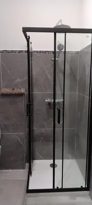 a shower with a glass door and a sink at Grand Magnifique Studio piscine et parking privé in Manosque