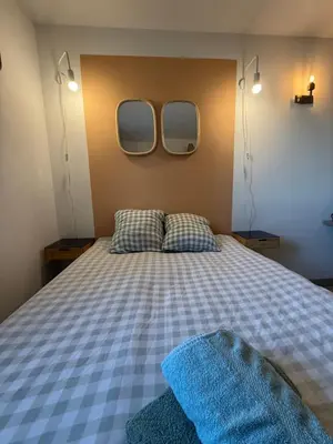 a bedroom with a bed with two mirrors on the wall at Le Clos d'Aix studio 106 parking in Aix-en-Provence