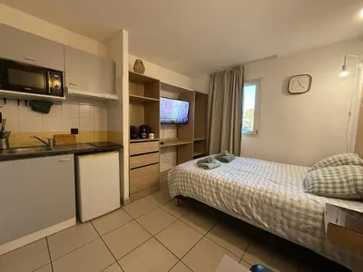 a small room with a bed and a kitchen at Le Clos d'Aix studio 106 parking in Aix-en-Provence