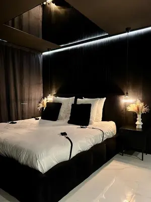 a bedroom with a large bed with a black headboard at BDSM TANTRA Love Room Salon-de-Provence in Salon-de-Provence