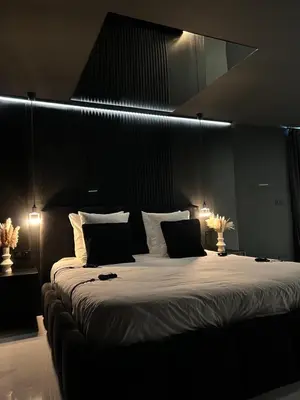 a large bed in a dark room with two lights at BDSM TANTRA Love Room Salon-de-Provence in Salon-de-Provence