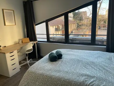 a bedroom with a bed with a desk and a window at L'Olivier - Joli duplex au cœur du centre ville à 2 pas de la Rotonde Mirabeau et des allées Provençales in Aix-en-Provence